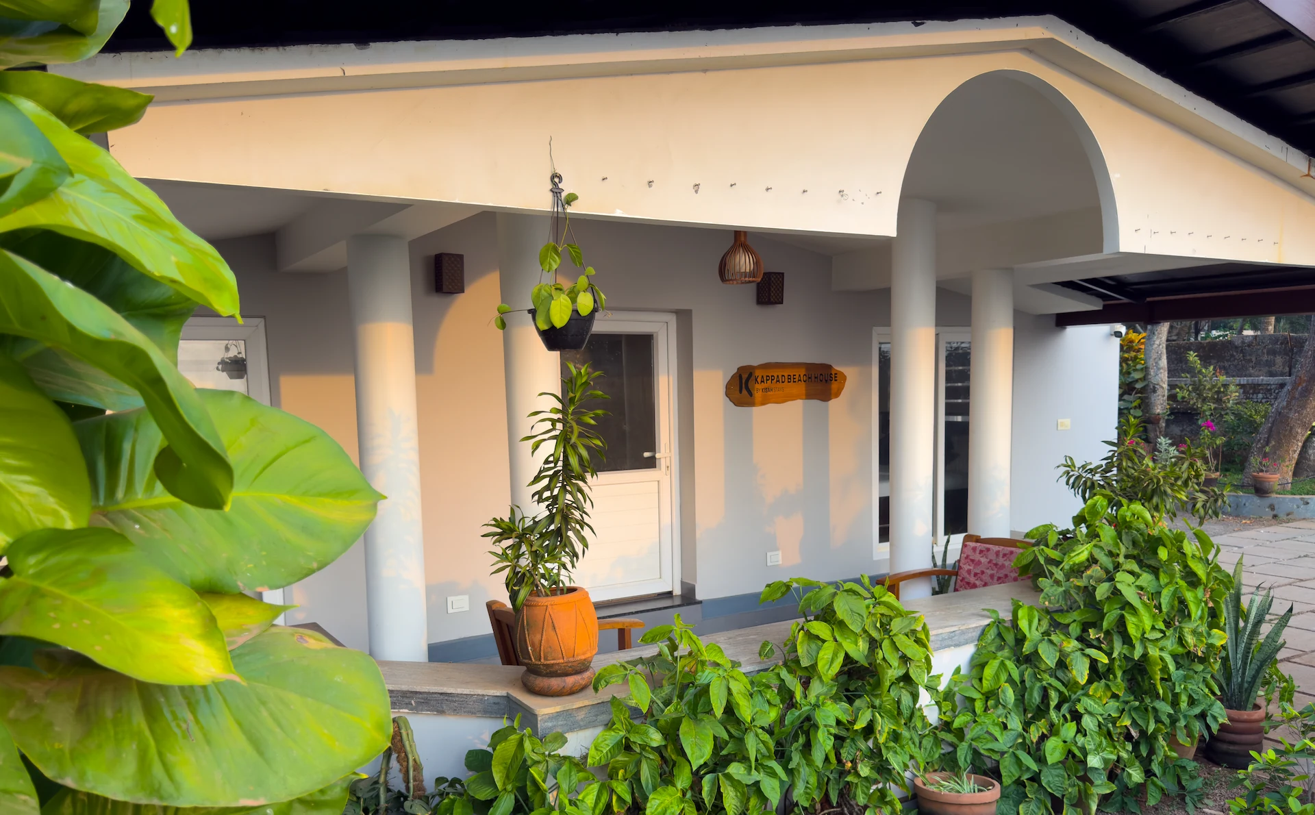 Kappad Beach House by Kisah Stays – a beautifully designed name board displayed in the veranda overlooking the serene courtyard. Surrounded by lush greenery and a peaceful coastal ambiance, the board welcomes guests to this luxurious beachfront retreat in Kozhikode, Kerala.