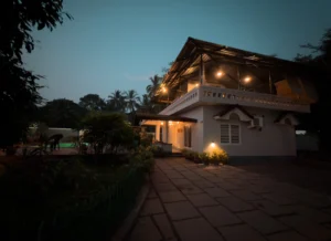 A stunning low-angle nighttime view of Kappad Beach House by Kisah Stays, beautifully illuminated against the dark sky. The elegant architecture, warm lighting, and serene coastal ambiance create a mesmerizing and inviting atmosphere for a luxurious beachfront stay in Kozhikode, Kerala