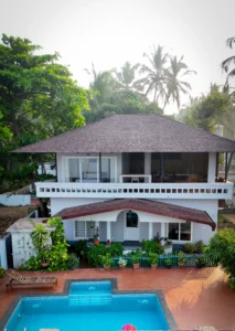 Aerial daytime view of Kappad Beach House by Kisah Stays, a luxury beachfront villa in Kozhikode, Kerala. Captured by a drone, the image showcases the villa’s private pool, lush greenery, and stunning coastal surroundings, with the Arabian Sea stretching into the horizon. A perfect retreat for a serene and scenic getaway.