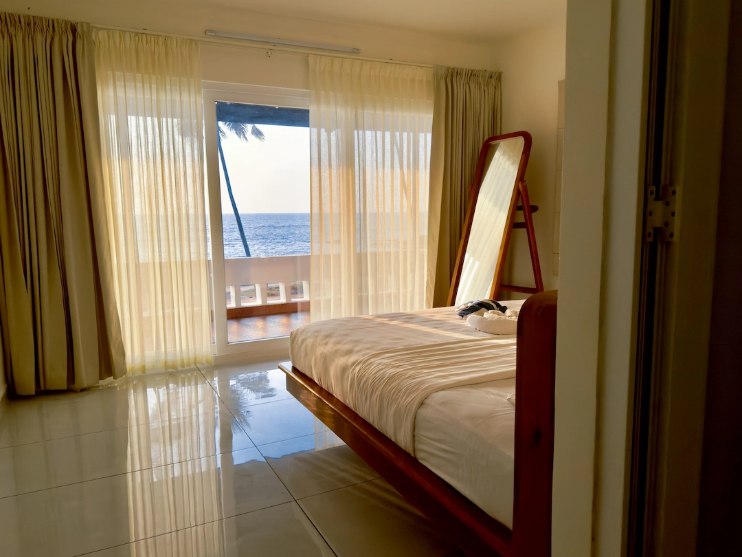 Image of Kappad beach through the bedroom of Kappad Beach House showcasing how you can wake up to the ocean views of kozhikode kerala