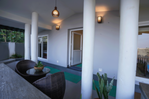 Kappad Beach House by Kisah Stays –  in the veranda overlooking the  courtyard. Surrounded by lush greenery and a peaceful coastal ambiance, the board welcomes guests to this luxurious beachfront retreat in Kozhikode, Kerala.