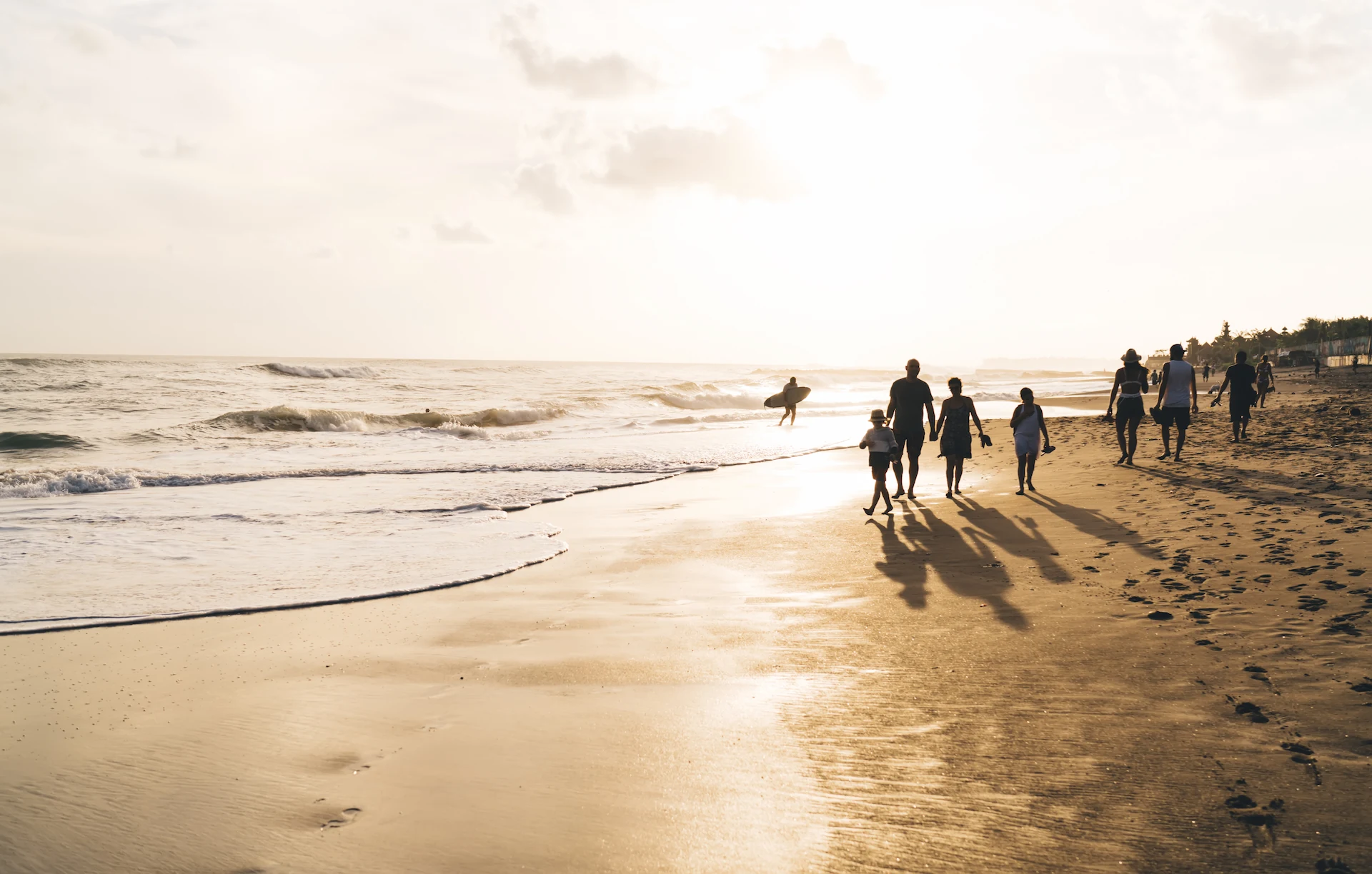 Silhouettes of people walking along Kappad Beach at sunset, with golden hues reflecting off the waves. This historic shoreline in Kozhikode, famous for Vasco da Gama’s landing, offers a serene and picturesque setting for evening strolls. A must-visit destination for beach lovers and history enthusiasts
